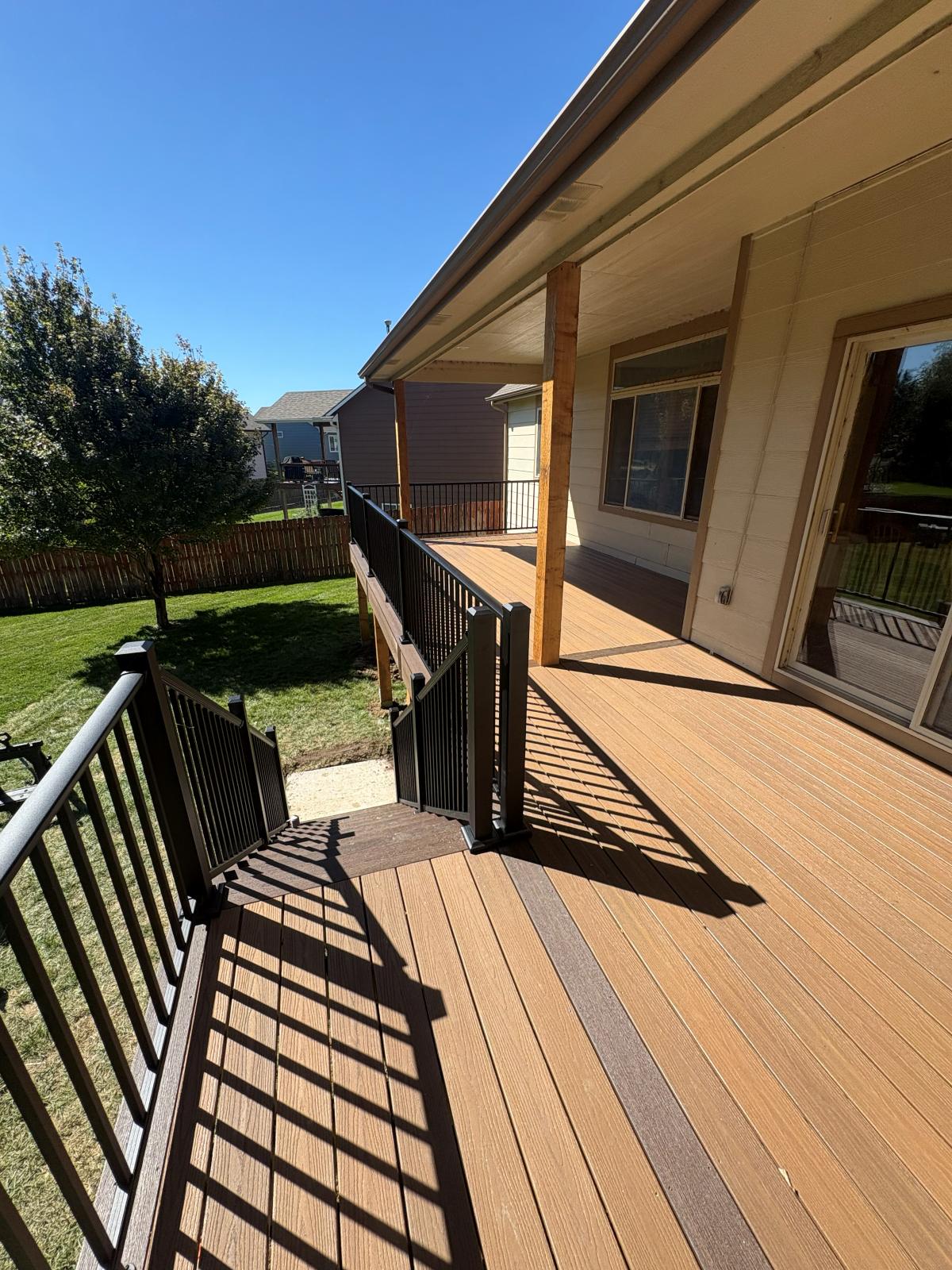 Composite deck surface with a two-tone border and a gated stair landing
