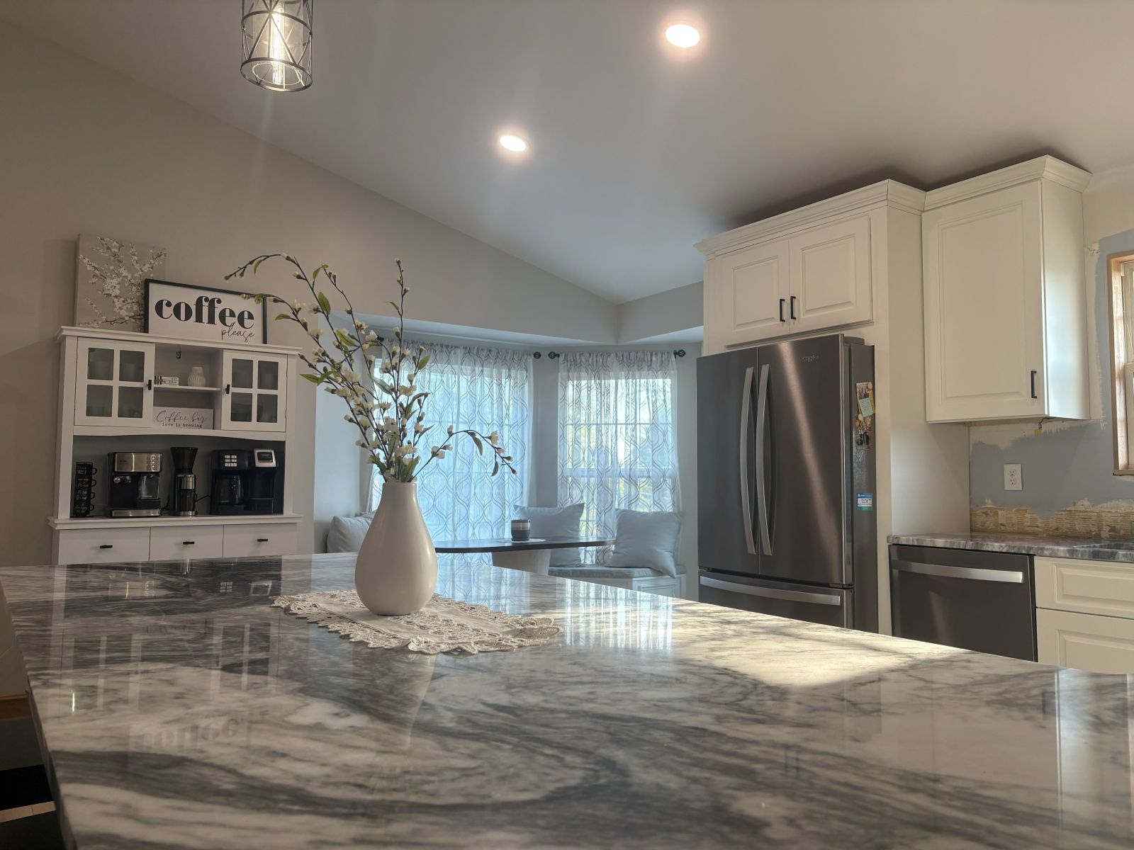 Granite island with the coffee bar and breakfast nook beyond